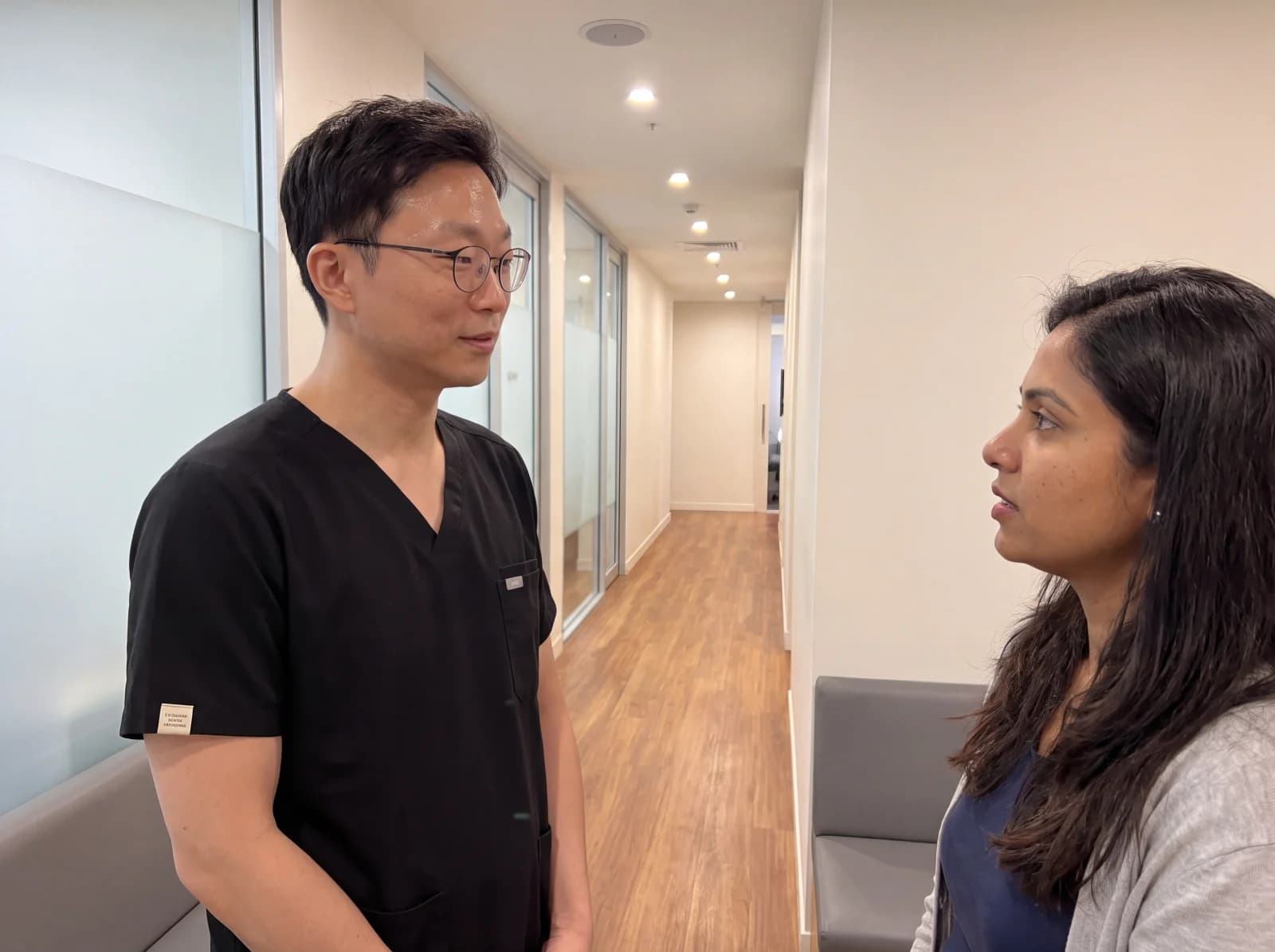 Dr Ryan Kim talking with a patient in the clinic corridor at Mirabel Dental Hornsby